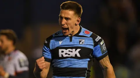 Josh Adams celebrates scoring a try for Cardiff