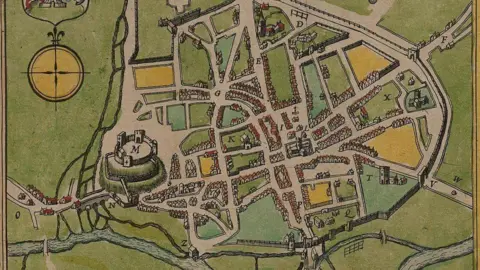 Public domain Castle on mound on left of plan with streets and houses