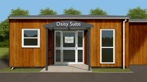Northamptonshire Health Charity An artist's impression of what the suite will look like, showing a white front door, with windows either side, clad with wood, a metal grey porch, a grey roof and trees behind the building. 