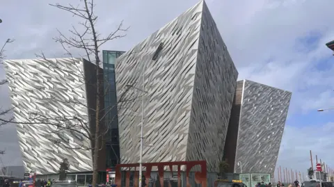 Titanic Belfast, sebuah bangunan yang terbuat dari tiga struktur tinggi, geometris, yang tertutup logam