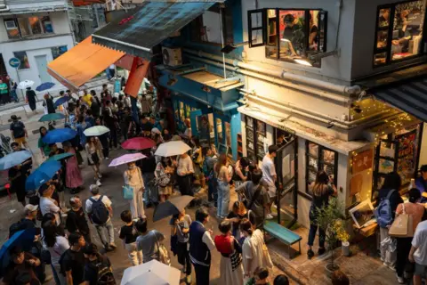 Getty Images Visitors pay tribute to independent bookstore 'Mount Zero' on its last day of business in Hong Kong on March 31, 2024. 
