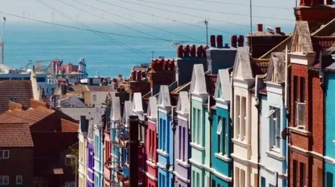 Getty Images An aerial shot of multi-coloured houses with the sea and amusements on Brighton Pier in the background