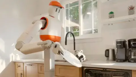 Sunday AI's Memo robot holds a plate in the kitchen and prepares to place it in the dishwasher