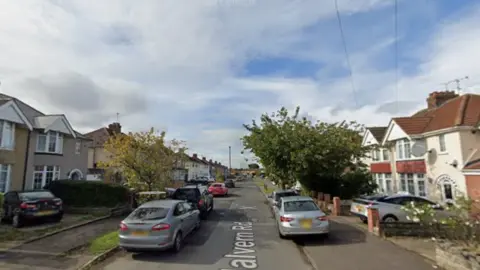 A screengrab of Malvern Road in Swindon which is a residential street. 1950s-style properties line both sides of the road, with cars parked on driveways and alongside the pavements.