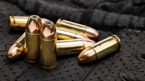 Getty Images A close-up shot of eight loose 9mm rounds sitting on a black blanket