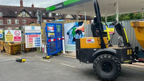 Julia Gregory/BBC A digger and fencing around the Asda Express petrol station in Bramley