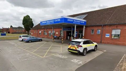 Exterior of Goole UTC. It is a single storey red brick building with a blue canopy over the entrance reading Urgent Treatment Centre