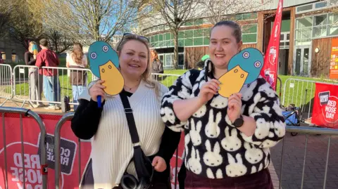 Emily Long and Sophie Coulthard, who are both holding up duck masks.