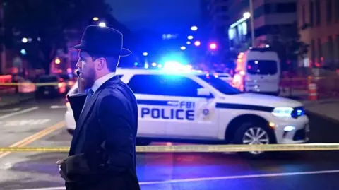 A man at a police cordon outside the shooting