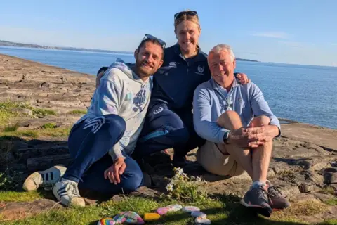 Scott Hastings Scott, right, with his 2  children Corey and Kerry-Anne - they are sitting adjacent  to the h2o  astatine  Wardie Bay, Edinburgh