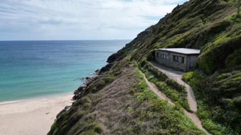 The bungalow on the cliff overlooking Porthcurno beach