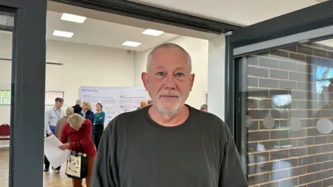 Phil McKenzie stood outside the doors of the consultation room at the Northway Community Hub in Tewkesbury