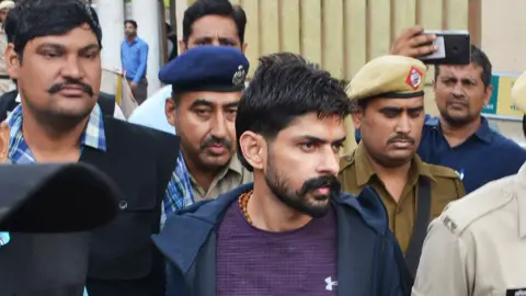 Hindustan Times via Getty Images Lawrence Bishnoi being escorted by police before appearing in Panchkula Court, on 13 November, 2019 in Panchkula, India.