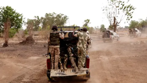Getty Images Soliders on the back of a military truck in Gwoza