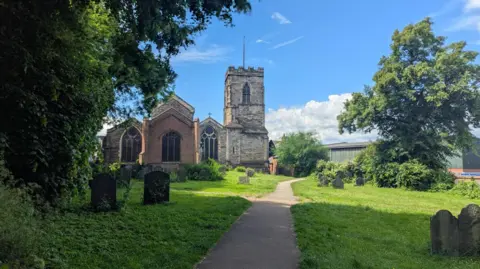 Gravestones and grass in front of a church