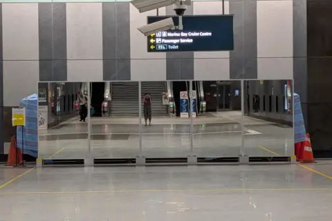 Kelly Ng/BBC Five panels of mirrors set up inside a remote train station in Singapore