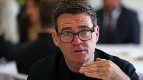 Andy Burnham wearing a black top
