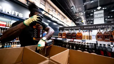 A worker removes bottles of American-made Jack Daniel's whiskey from a shelf at the Liquor Control Board of Ontario (LCBO) Queen's Quay store in Toronto, Ontario, Canada.