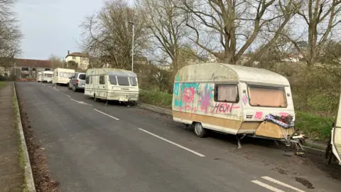 Five caravans lined up on Roman Way in Glastonbury