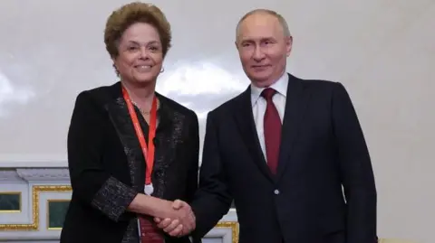 De Russische president Vladimir Poetin schudt de hand van president Dilma Rousseff van de Nieuwe Ontwikkelingsbank (NDB) tijdens een bijeenkomst in de zijlijn van het Internationaal Economisch Forum in Sint-Petersburg op 6 juni 2024.