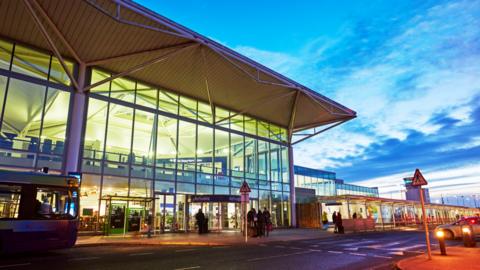 A picture of the exterior of Bristol Airport, taken at dusk. 