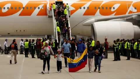 Reuters Venezuelan migrants disembark an airplane as they arrive on a repatriation flight from Mexico at the Simon Bolivar International Airport, in Maiquetia, Venezuela on 20 March