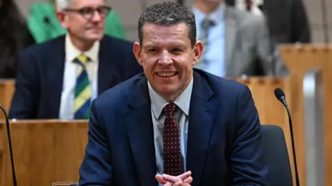 Rhun ap Iorwerth smiling in the Senedd.
