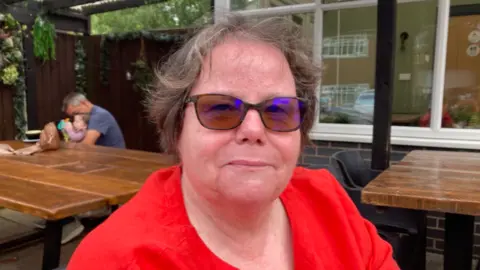 Woman in red top and vary-focal glasses.