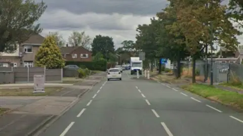 Google A street with houses on the left hand side and cars and a van in the distance
