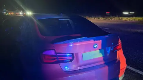 Leicestershire Police A red BMW car by the side of the road at night
