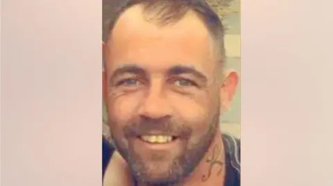 A close-up picture of Andrew Roche, who is smiling and looking directly into the camera.