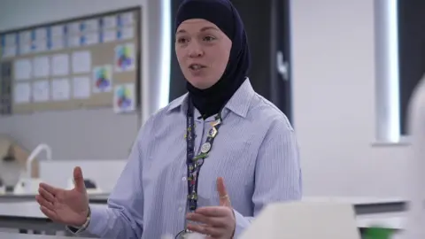 Assistant principal of Oasis Academy Don Valley, Dana Abdulkarim, wears a striped blue shirt and a dark blue head scarf
 