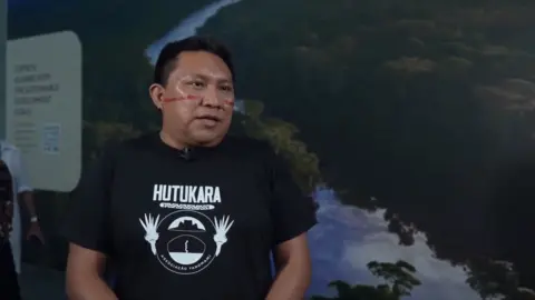 Brazilian indigenous leader stands during interview with BBC at COP30