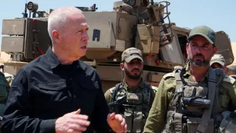 Israeli Defence Minister Yoav Gallant (L) visits troops near Israel's border with the southern Gaza Strip (7 May 2024)