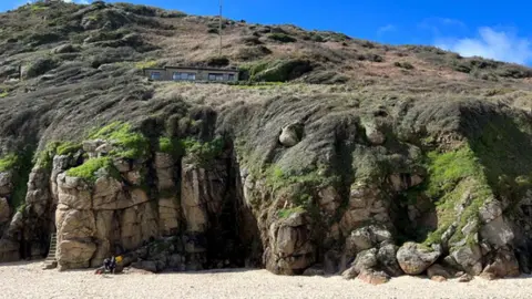 Clive Emson The bungalow on the cliff seen from the beach below