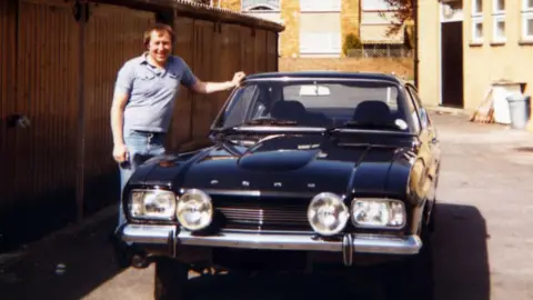 David Doyle David Doyle with longer hair stood next to his Capri in 1982.