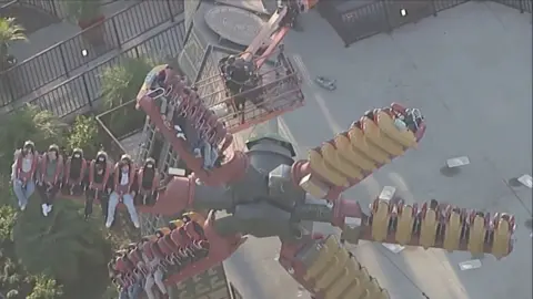 Firefighters helping people stuck on ride. 