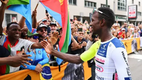 Getty Images Biniam Girmay greets fans - including ones waving Eritrean flags - at the 2024 Tour de France 