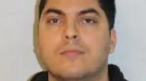 Met Police Blurry police-issued image of Che Homersham, wearing a black top and looking toward the camera.