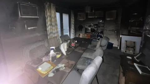 Jamie Warden/Electrical Safety First A dining room that is covered in black smoke residue. 