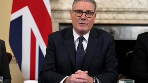 File photo of Sir Keir Starmer in the Cabinet meeting room of 10 Downing Street, wearing a dark suit, dark blue tie and with a Union Jack in the background.