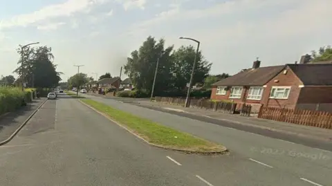 Residental street Ribbleton Hall Drive in Preston on a cloudy day.