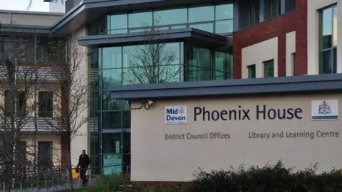 The outside of a council building. The building is called Phoenix House and is part of Mid Devon District Council.