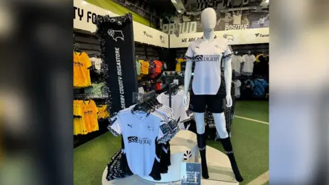 An image of Derby County Women's team shirt on display at Pride Park Stadium