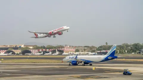 Getty Images The image shows an IndiGo aircraft on the runway after landing whilst an Air India plane takes off at Chhatrapati Shivaji Maharaj International Airport in Mumbai.