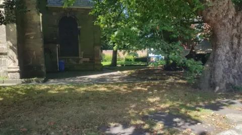 A shady churchyard on a sunny day