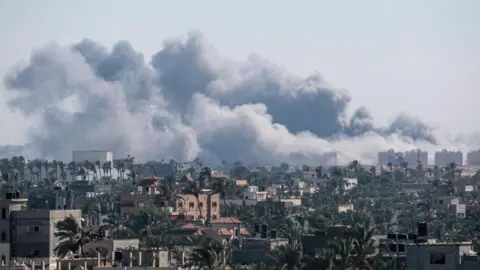 Getty Images A picture taken from Deir el-Balah shows smoke billowing after an Israeli strike on Khan Yunis on August 16, 2024, amid the ongoing conflict between Israel and the Hamas militant group