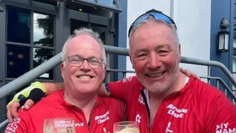 Supplied Nick Apperley and Ally McCoist. They are both smiling and looking into the camera. They are wearing red tops and have their arms around each other's shoulders. 