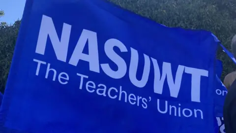 A large blue flag which says "NASUWT The Teachers' Union"