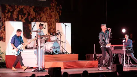A band, Keane, playing on a stage.